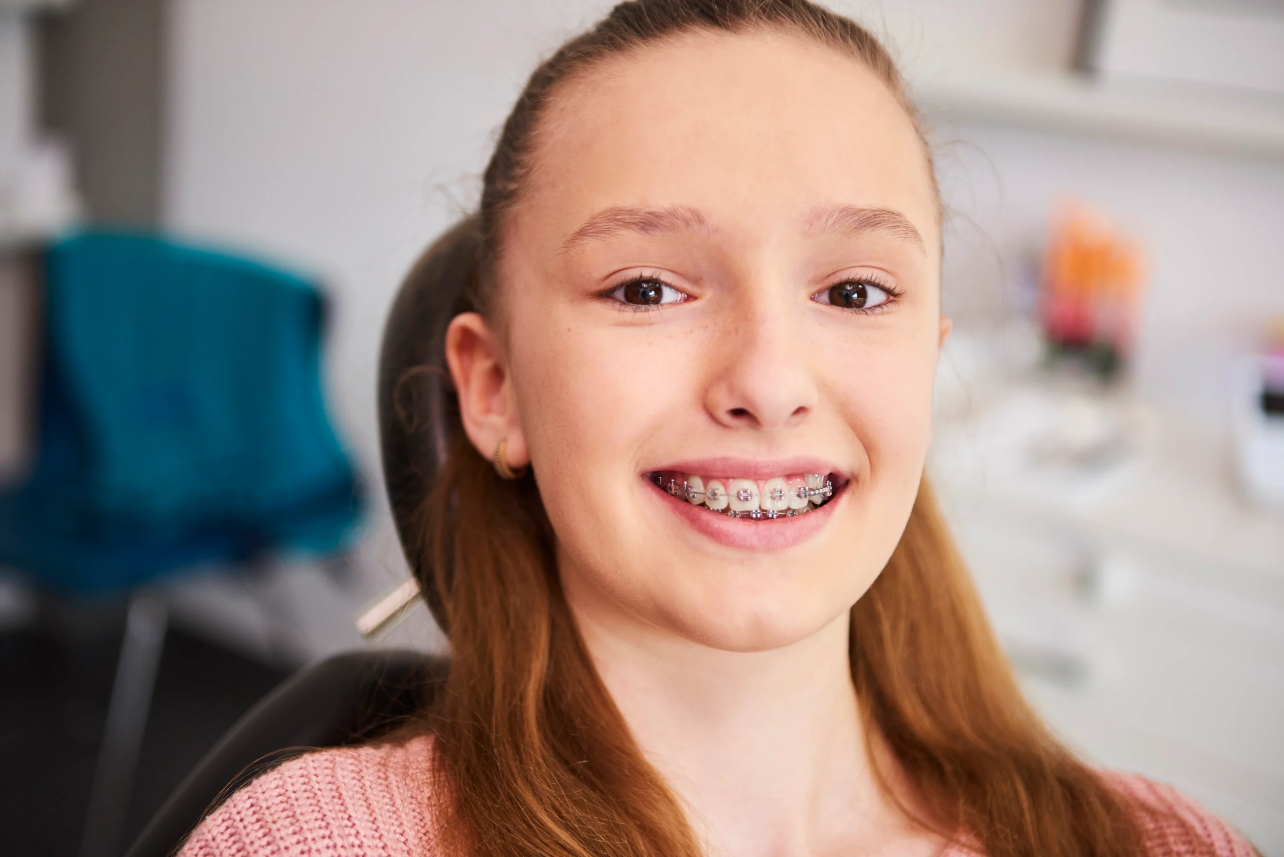 portrait smiling child with braces dentist s office scaled